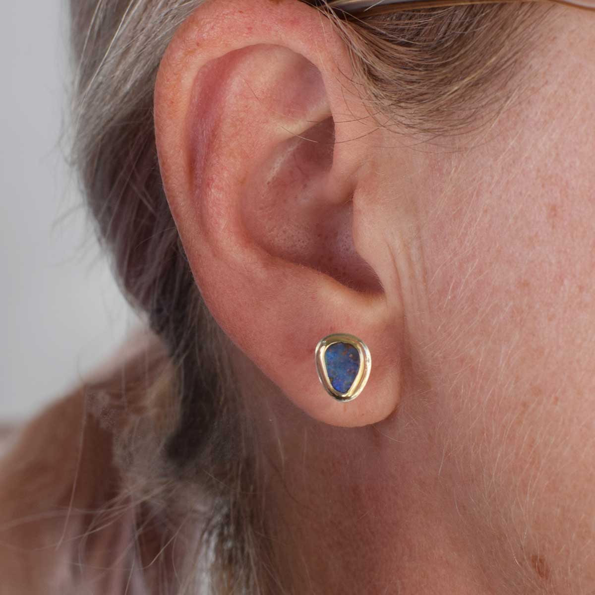 Handcrafted one-of-a-kind opal earrings with asymmetric gold and silver design