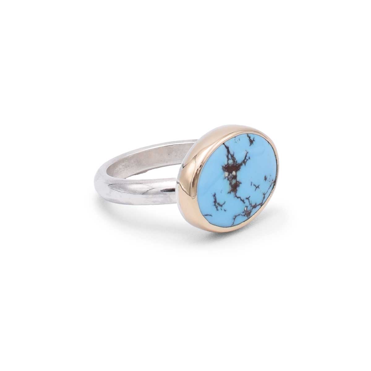 Ring with a blue stone and rose gold accents on a white background