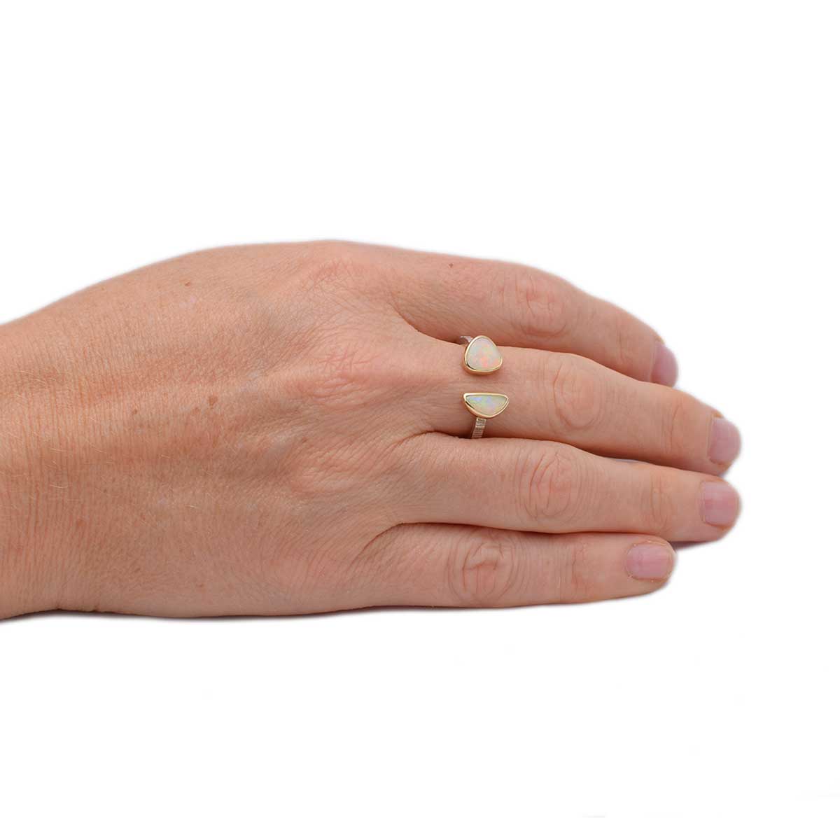 Close-up of dual Coober Pedy opals in Celestial Duet ring showing unique play of colours and handcrafted 14K gold setting