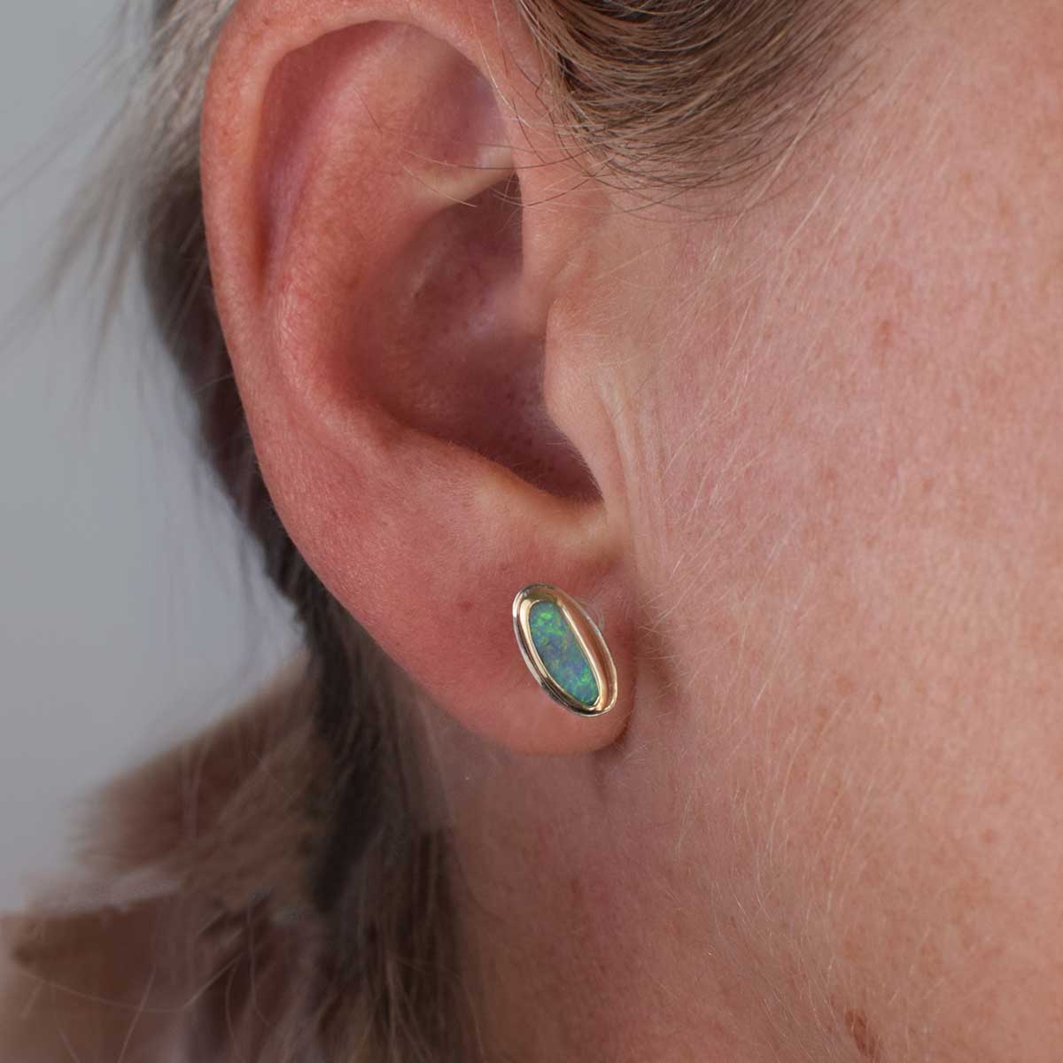 Mismatched boulder opal stud earrings in 9K gold and sterling silver, featuring natural Australian opals with unique colour play