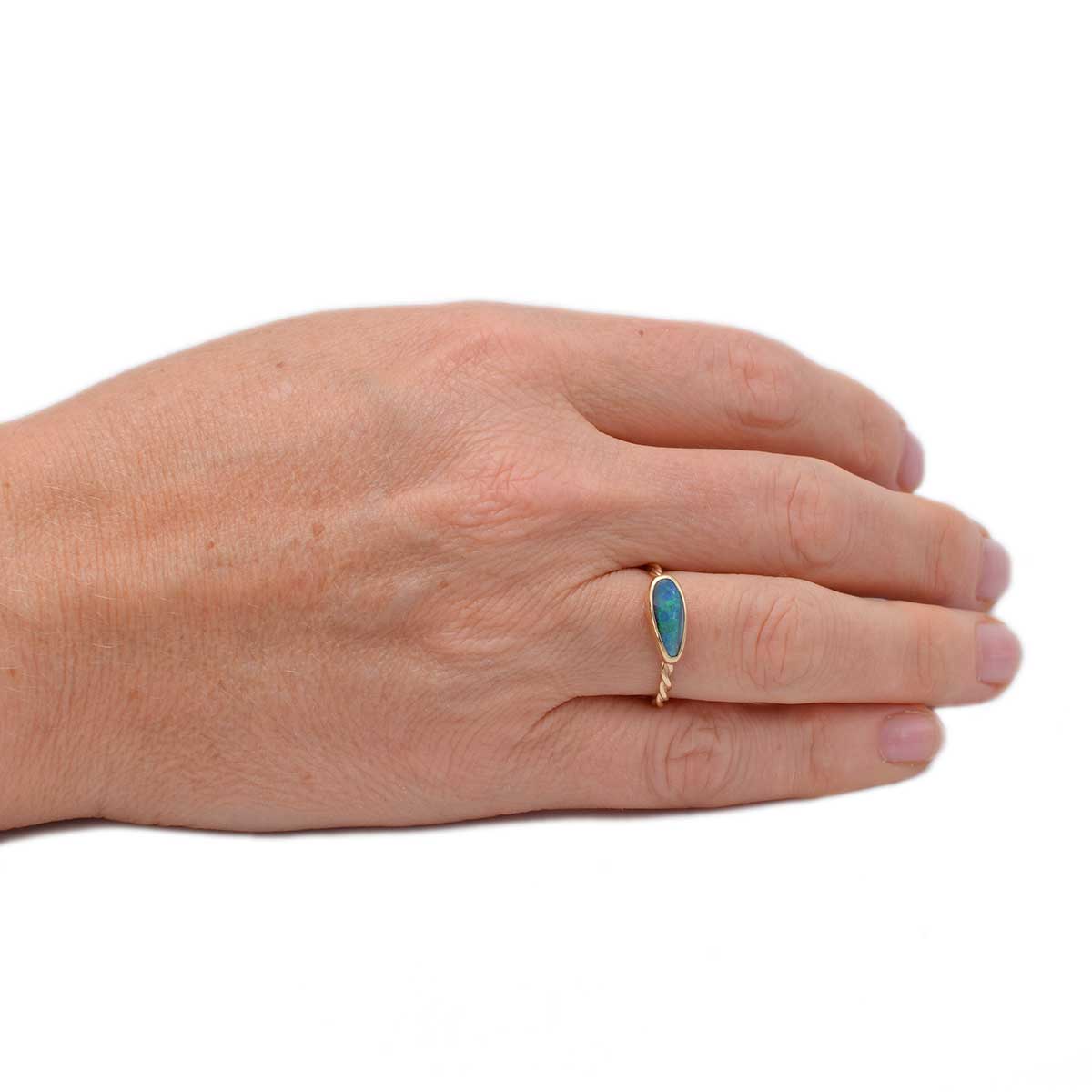 Close-up of teardrop boulder opal in Ocean Teardrop ring (ORG043) revealing detailed blue-green colour play and handcrafted 9K gold bezel