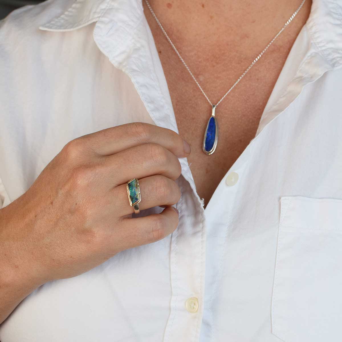 Side view of ORMM110 Coral Geometry ring showing boulder opal's unique geometry in east-west 14K gold setting with sterling silver band